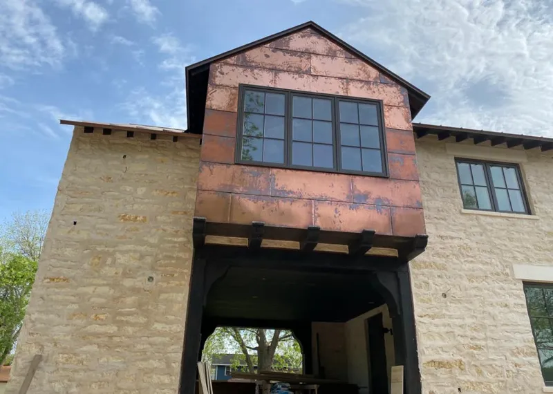 Copper metal panel facade on a stone building for Skylight Installation in Henniker